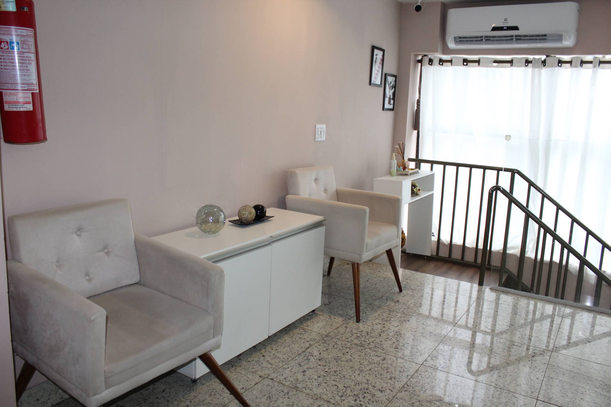 Sala com poltronas brancas e janela ampla